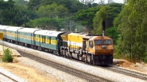 Громкий Индийский поезд проезжает станцию и приветствует пассажиров