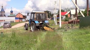 Трактор МТЗ 80 косит траву обочин дороги