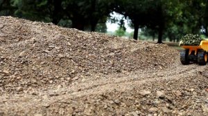 Карьерный самосвал, трактор и грузовик возят тростник