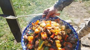 Куриная печень с овощами в казане на костре.