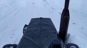 Трактор МТЗ 82.1 чистит снег  быстросъёмным гидроповоротным отвалом на передней навеске.