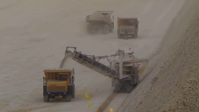 Wirtgen surface miner loads limestone on BELAZ trucks. Карьерный комбайн Wirtgen и БелАЗы смотреть онлайн