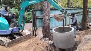 Установка бетонных колец для канализации с помощью мини-экскаватора