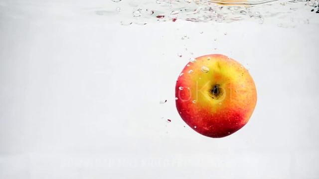 Juicy red apple on isolated white background in slow motion. Apple is immersed in water with bubble смотреть онлайн