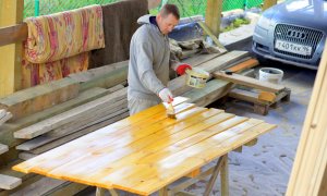 Покраска забора из доски антисептиком с добавлением колера.