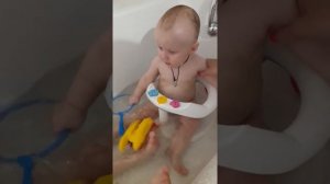 Дети весело купаются в ванной. Ребенок смеется и испугался всплеска воды.