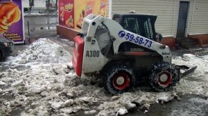 Минитрактор Bobcat (Бобкэт) удаляет наледь и снег навесным скрепером