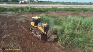 Бульдозер очищает участок от высокой травы.