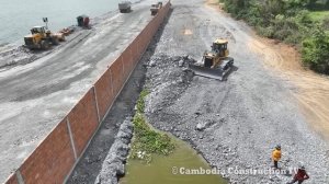 Осушение участка на озере. Бульдозер разравнивает грунт, привезенный самосвалами