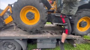 Погрузка экскаватора погрузчика JCB 3CX Super на платформу для перевозки.