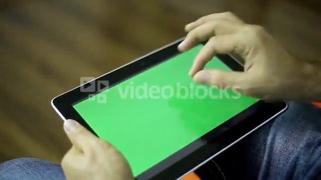 A man is holding a tablet with a green screen close-up. смотреть онлайн