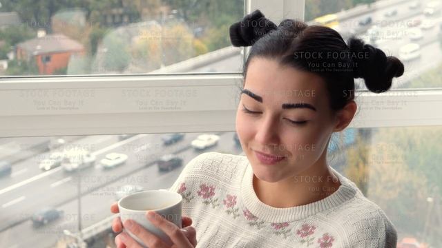 Charming young woman sitting near window and drink coffee смотреть онлайн