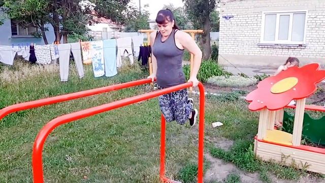 Тренировка на улице. Девушка отжимается на брусьях. Тренировка груди. Все подходы. смотреть онлайн