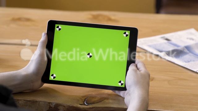 Young guy holding the tablet with touching green screen with tracking marks, motionless. Stock смотреть онлайн