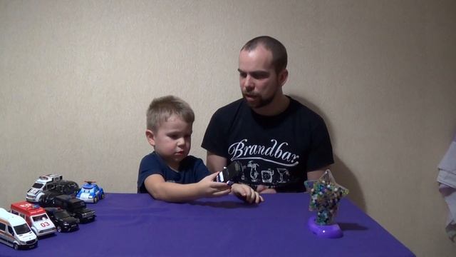 Мисье Филипп и Папа рассматривают полицейские машинки