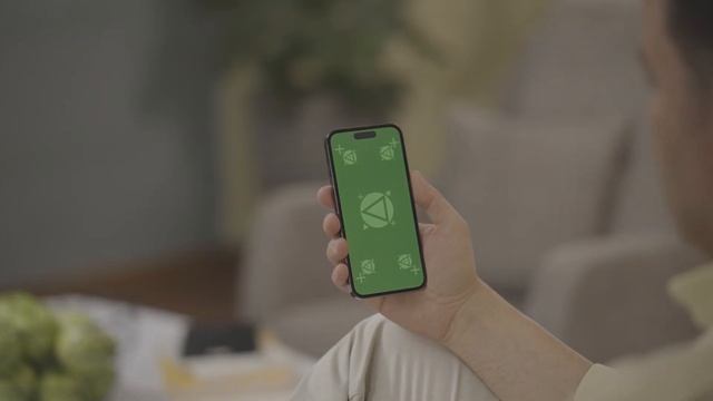 Free iPhone 14 pro Green screen footage 4k _ Man touching iPhone on sofa in living room смотреть онлайн