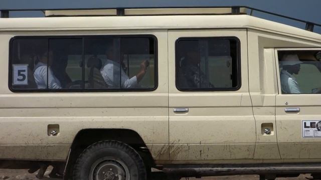 A Toyota Land Cruiser safari car runs through Serengeti National Park.And one Maasai people.Africa смотреть онлайн