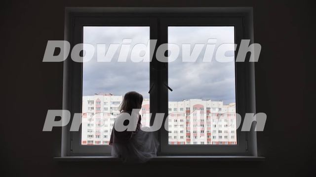 Lonely child girl sitting on the windowsill at the window in the apartmen. смотреть онлайн