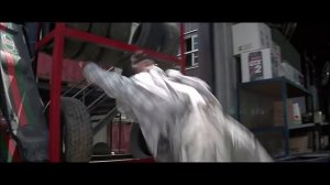 Jackie Chan fights with Cougar's thugs in an auto repair shop in the movie THUNDERBOLT (1995)