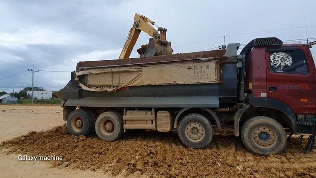 Excavator Komatsu pc210 digging soil and loading HYUNDAI trago 25T dump track for Road construction смотреть онлайн