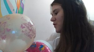 Симпатичная девушка тренирует лёгкие, надувая шарик