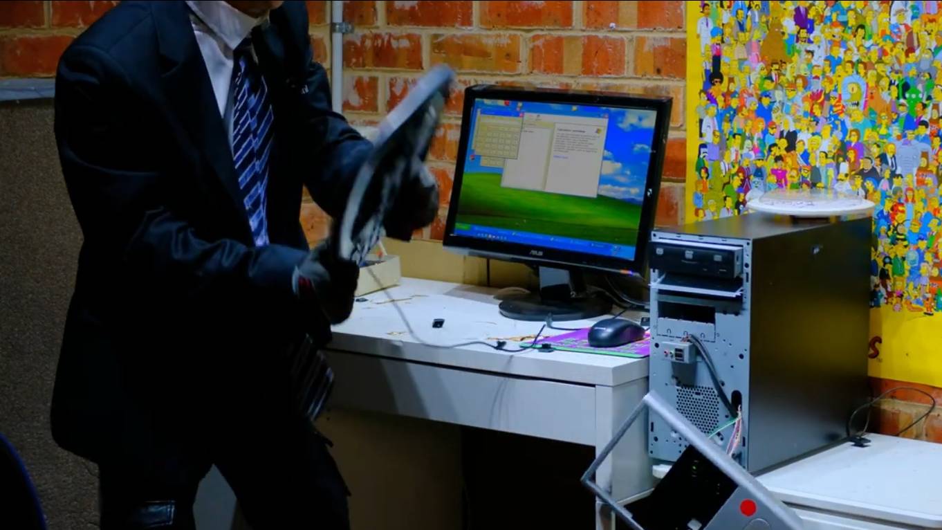 Злой офисный работник ломает компьютер