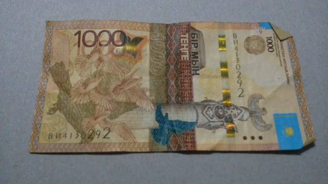 БАНКНОТА 1000 ТЕНГЕ № серии ВИ4130292 на картонной поверхности Девятого Марта - ДЕНЕЖНЫЙ ПОТОК смотреть онлайн