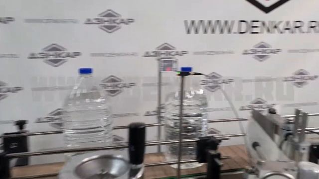 Укупоривание ПЭТ объемом 5Л с последующем нанесением самоклеющейся этикетки. смотреть онлайн