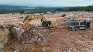 Строительство,  каменный карьер, большой экскаватор, долбит камни