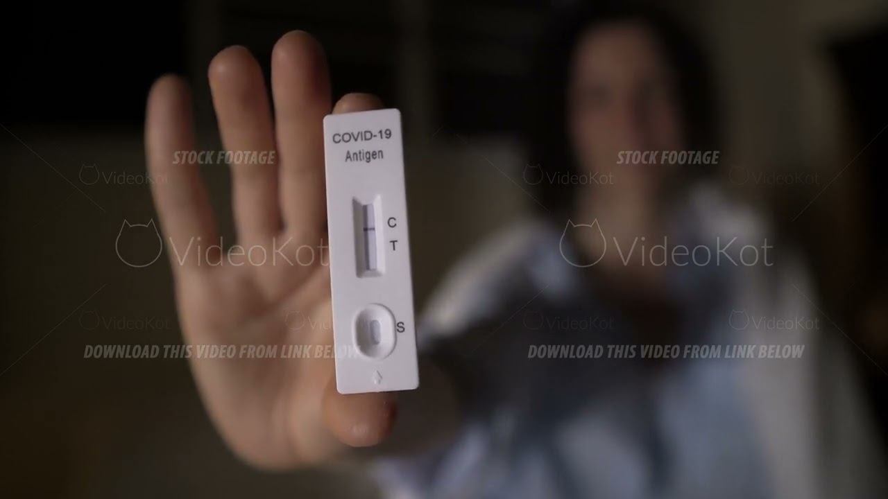 Woman shows close-up of a negative antigen rapid test for covid19 in evening at home смотреть онлайн