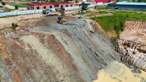 Бульдозер KOMATSU D68E и грузовики засыпают котлован.