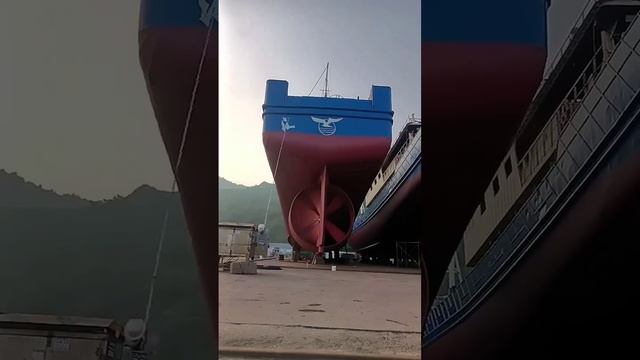 Азиатский работяга вручную расписывает корабль, стоя на земле. смотреть онлайн