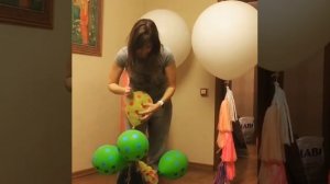 Девушка лопает шарики после праздника