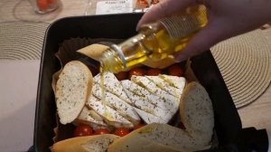 Мужчина на кухне. Сыр в аэрогриле с багетом и томатами.