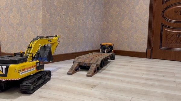 КрАЗ разгружает экскаватор