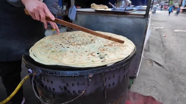 中國西安城市高樓下的大早市，人頭攢動，上班族、學生、居民搶購新鮮食材、早餐，碩大的蔥花大餅，動感的雞蛋煎餅，火熱的新疆烤餅，現做手工蛋捲，火烤四川燻臘肉，萬能的修鞋大師，街頭免費剃鬚，無所不有！