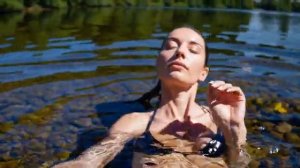 Девушка купается в озере