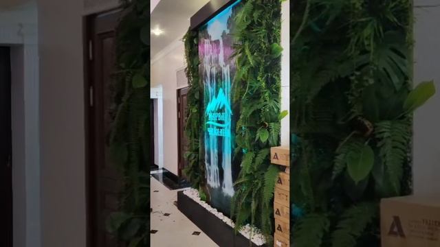 Водопад с оформлением искусственными растениями и логотипом заведения. смотреть онлайн