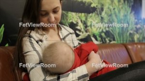 Young mother breastfeeds the small child