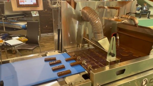 Покрытие шоколадной глазурью кондитерских изделий на глазировочной машине от компании DitoGroup.