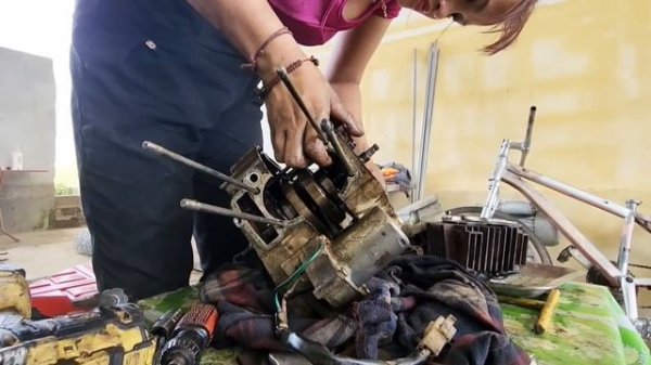 Genius girl repairs and restores a motorbike engine.