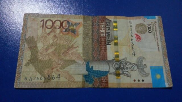 БАНКНОТА 1000 ТЕНГЕ № серии БД2666864 на фиолетовой поверхности Шестнадцатого Марта - ДЕНЕЖНЫЙ ПОТО смотреть онлайн