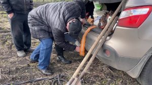 Застряли в поле. Вытаскиваем автомобиль из грязи. Четыре мужика и девушка выталкивают автомобиль.