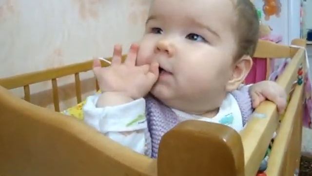 Маленькая Ксюша стоит и смотрит телевизор Little Ksusha stands and watches TV.