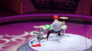 клоун за барабанной установкой.