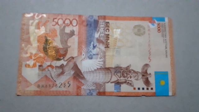 БАНКНОТА 5000 ТЕНГЕ № серии ВЖ6376235 на картонной поверхности 24 Февраля ДЕНЕЖНЫЙ ПОТОК