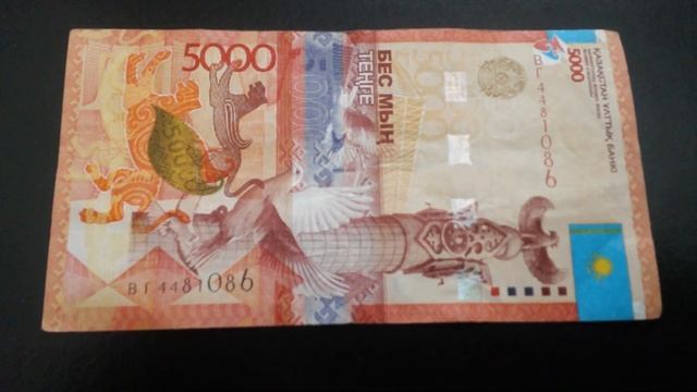 БАНКНОТА 5000 ТЕНГЕ № серии ВГ4481086 на чёрной поверхности Четвёртого Марта - ДЕНЕЖНЫЙ ПОТОК