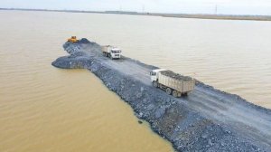 Строительство, засыпка щебня, дорога через озеро