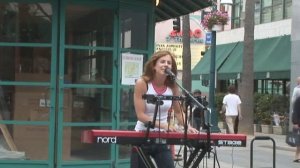 Девушка на улице красиво поёт.