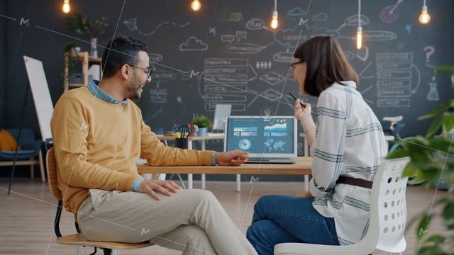 Joyful people girl and guy talking in office discussing business using laptop at table смотреть онлайн
